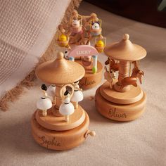 three wooden toy carousels sitting on top of a bed