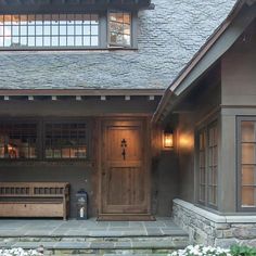 the front entrance of a house with two benches