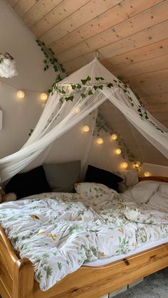 a bed that has some lights on the side of it and is covered in white netting