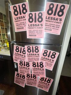 pink and black numbered stickers on the side of a stainless steel refrigerator in a kitchen