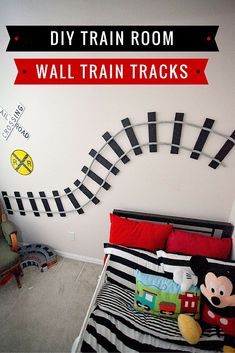 a bedroom with mickey mouse and train tracks on the wall above it is decorated in black and white