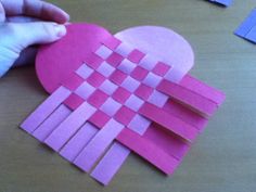 someone making a heart out of construction paper