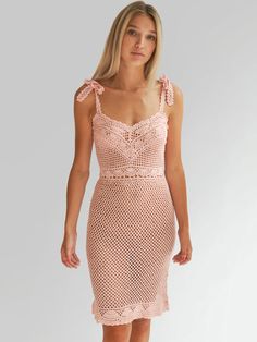 a woman is wearing a pink dress with an open back and crochet detailing