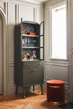 an old fashioned china cabinet in the corner of a room