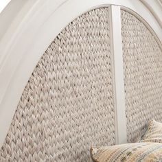 a white wicker headboard with two pillows on it