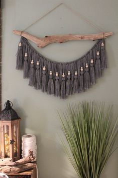 a wall hanging made out of driftwood with tassels