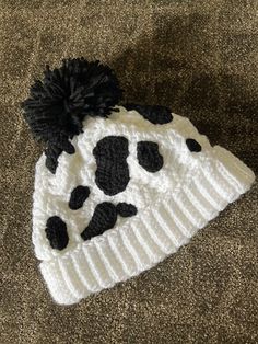 a white and black cow print knitted hat