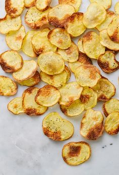 sliced potatoes on a white surface with seasoning