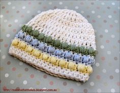 a crocheted hat sitting on top of a polka dot table