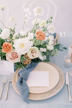 a table setting with place settings and flowers