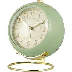 a green alarm clock sitting on top of a metal stand with a gold ring around it