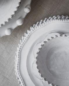 two white plates sitting on top of a table covered in pom - poms