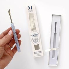 a person holding a toothbrush in front of a box with it's packaging