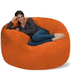 a woman sitting on an orange bean bag chair