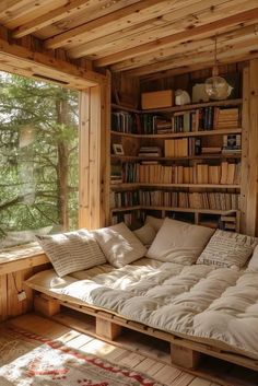 a couch made out of wooden pallets in front of a window with bookshelves