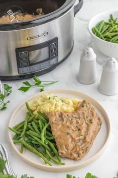 a plate with mashed potatoes, green beans and gravy next to an instant pot