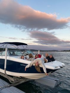 several people are hanging out on the back of a boat