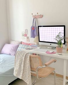 a white desk with a computer on top of it next to a chair and bed