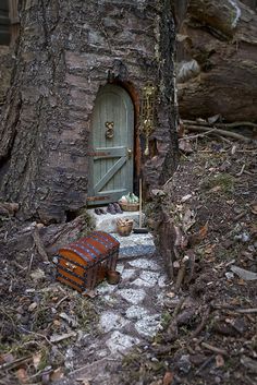 a trunk with a door in it sitting next to a tree