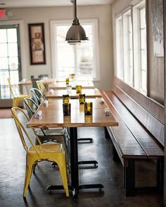 a long table with yellow chairs and beer bottles on it