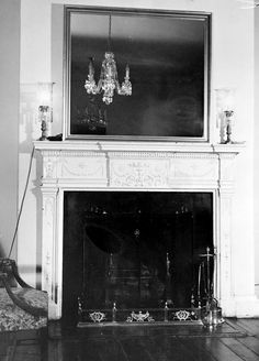 an old fireplace in a living room with chandelier