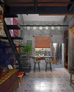 a living room filled with furniture next to a stair case