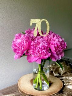 pink carnations in a glass vase with the number seventy