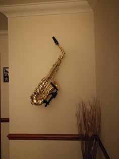 a saxophone mounted to the wall next to a vase