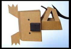 an animal made out of cardboard with scissors in it's mouth and eyes open