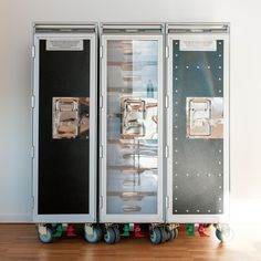 two large metal containers sitting on top of a hard wood floor next to each other