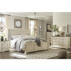 a white bed sitting in a bedroom on top of a hard wood floor next to a window