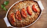 a casserole dish with tomatoes on top