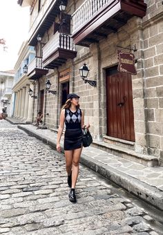 a woman walking down the street in front of a building