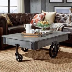 a coffee table sitting on top of a rug in a living room next to a couch