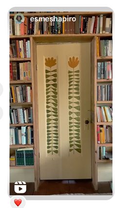 an open door in front of a bookshelf with flowers painted on the doors