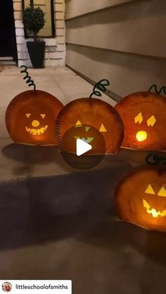 pumpkins with faces carved into them sitting in front of a house