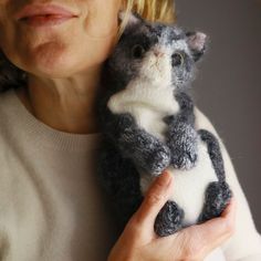 a woman holding a stuffed cat in her hands