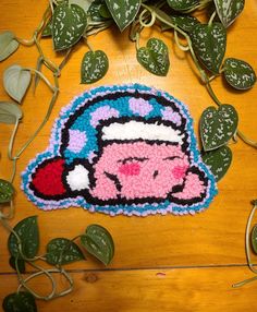 an embroidered patch with a pink pig wearing headphones on top of a wooden table