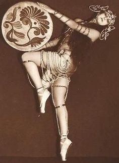 a woman is dancing with a large plate on her head and legs, in the air