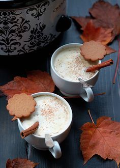 two mugs filled with hot chocolate and cinnamon