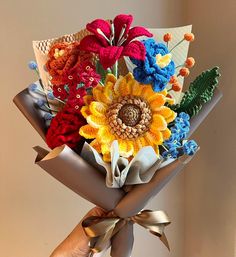 a hand holding a bouquet of colorful flowers