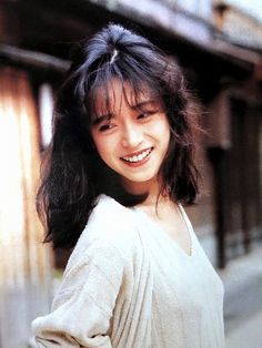 a woman with long black hair smiling at the camera