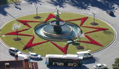 an aerial view of a fountain in the middle of a parking lot