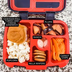 an open red lunch box filled with different types of food and words on the lid