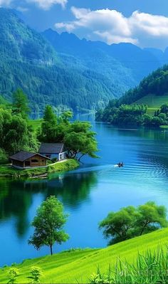 a lake surrounded by lush green hills and trees with a house on the shore next to it