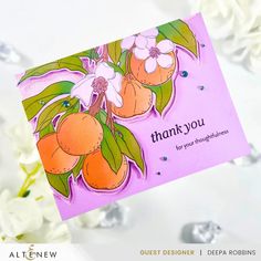 a thank you card with oranges on it and flowers in the background, surrounded by white flowers