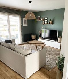 a living room filled with furniture and a flat screen tv on top of a wooden table