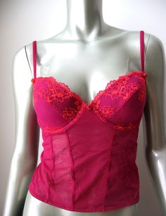 This hot berry color  camisole tank top is constructed of sheer mesh with padded contour underwire cups covered with gorgeous floral embroidery. Sheer stretch mesh bodice with rear 3 column, 1 row hook and eye cushioned back closure. Stretch rear adjustable straps with silk rose at front. One silk rose centered at gore. A stunning piece to make you feel special and captivating! Style No.:  Color: Berry Size: 36B Materials: 58% Nylon, 30% Rayon, 12% Spandex Condition: Brand new With Tag Inventory# VI0053 Berry Color, Silk Rose, Silk Roses, Tank Top Camisole, Feel Special, No Color, Cami Tanks, Floral Embroidery, Bralette