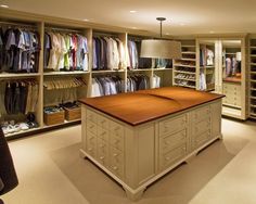 an organized closet with lots of clothes on the shelves and drawers in front of it