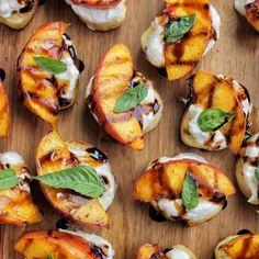 grilled peaches with whipped cream and basil on a wooden cutting board, ready to be eaten